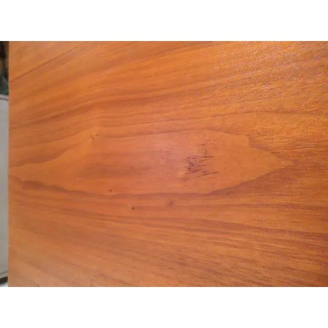 This vintage modern table in the style of Paul McCobb features a square walnut top, smooth lines, and light grain on a set...