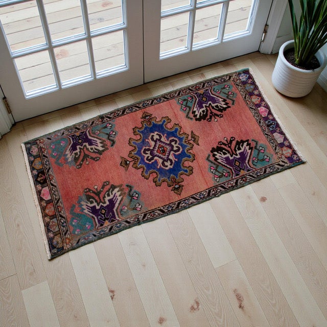 This charming vintage piece features a warm salmon-pink field adorned with a striking central medallion and expressive...