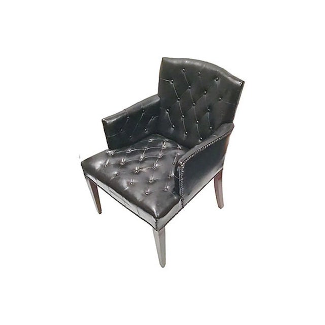 Mid-Century Modern black leather bergére with diamond button tufting, nailhead trim, and tapered wooden legs. No maker's...
