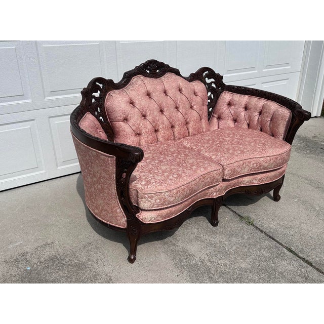 An absolutely charming antique Victorian loveseat featuring a beautifully hand-carved solid walnut frame paired with its...