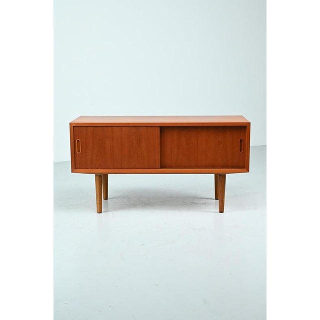 Hundevad lowboard made of teak veneer and with 2 sliding doors. This cabinet has new legs. Unfortunately it has only one...