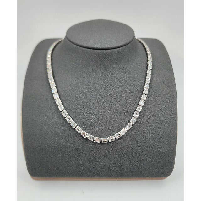 This elegant necklace showcases a series of natural emerald-cut white diamonds, totaling 21.84 carats, each set in...