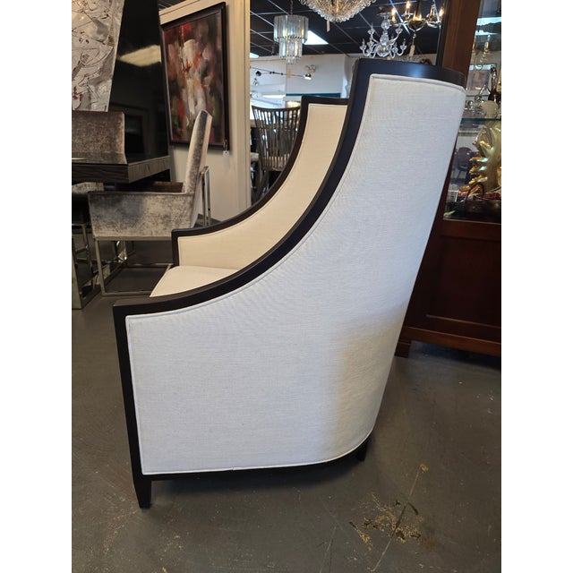 This is a Bernhardt chair, featuring a high back, dark wood frame and light colored fabric upholstery.