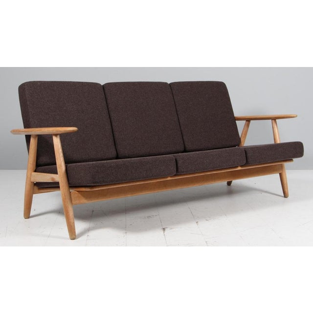 Hans J. Wegner three-seat sofa made of solid oak. New upholstered with 100% New Zealand wool. Model 240, made by GETAMA....