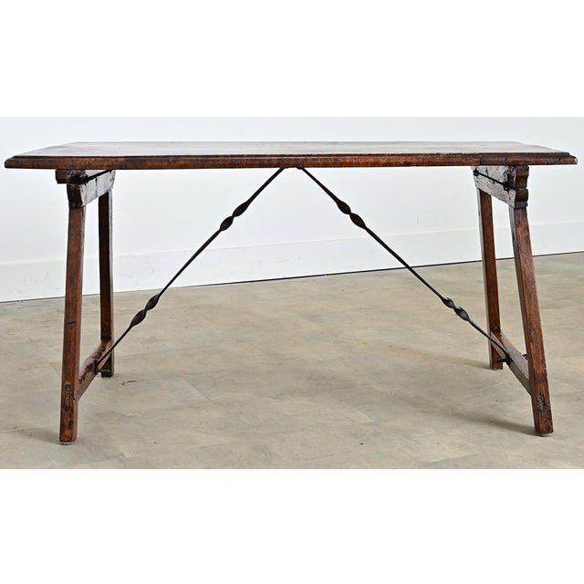 A multi-purpose Spanish fratino table dating to the 18th century, made of walnut construction with a single plank on top...