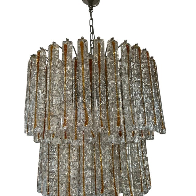 A stunning Italian chandelier by Mazzega, composed of clear and amber Murano glass planks, each individually hand-blown...
