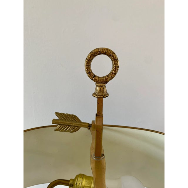 A classic bouillotte lamp rendered in warm brass, distinguished by its sculptural double dolphin motif and clean, tailored...