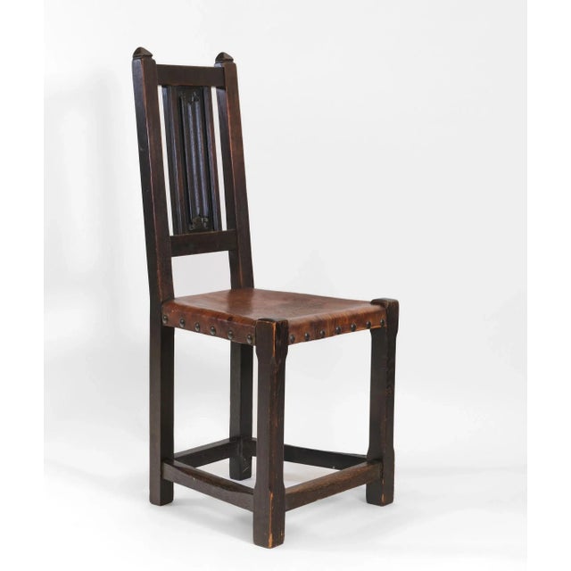 Arts & Crafts movement oak & leather arrowhead side chair with single linen fold central carved splat. Circa 1905....