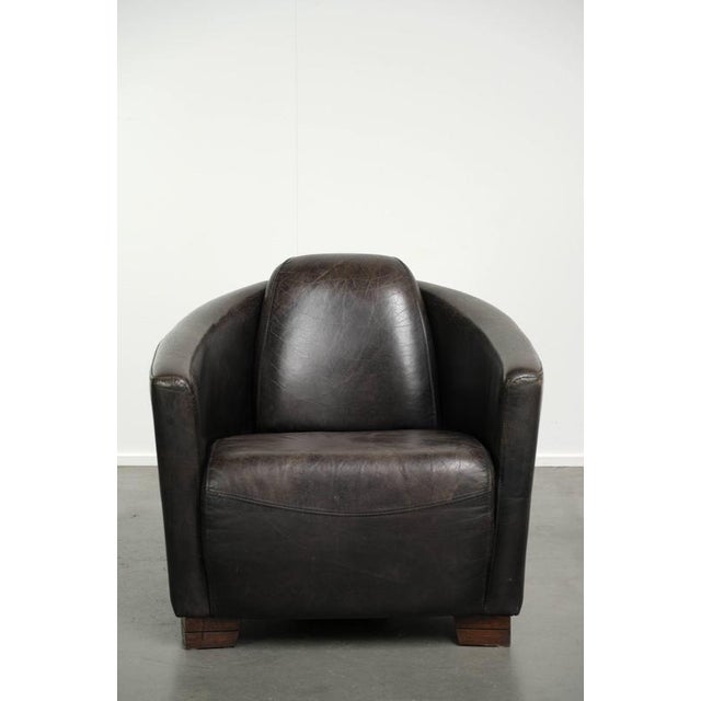 This Aviator design armchair is made of grained cowhide leather in a dark color scheme and has a distinctive look. The...