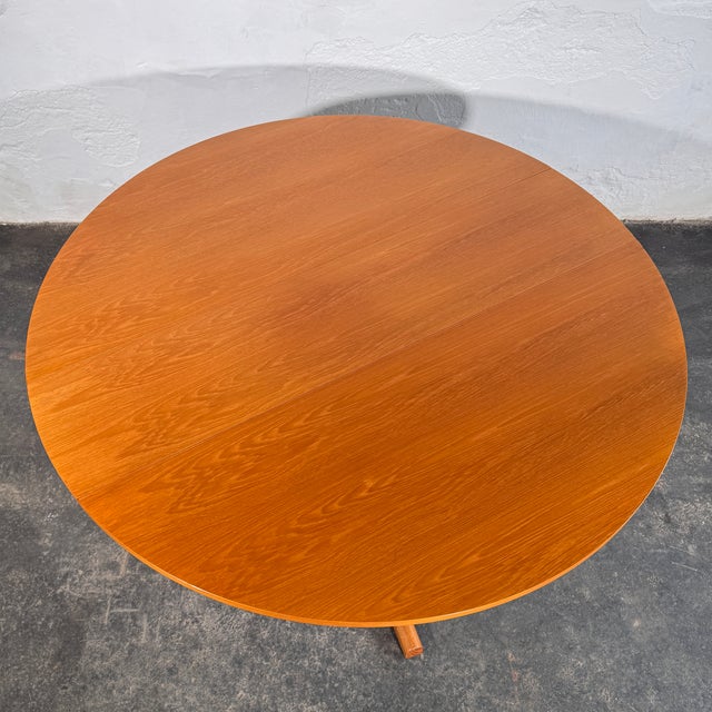 This drop leaf dining table is a versatile and practical example of British mid-century furniture design from the 1960s....