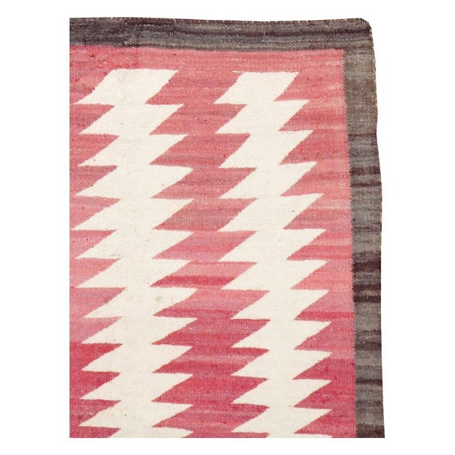 A vintage American flatweave throw rug handmade by the Navajo tribe during the mid-20th century. Measures: 2' 7" x 4' 4".