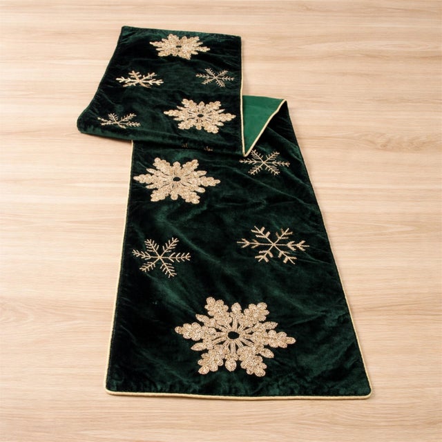 Dress your holiday table in luxurious seasonal style with this emerald velvet snowflake table runner, designed to bring...