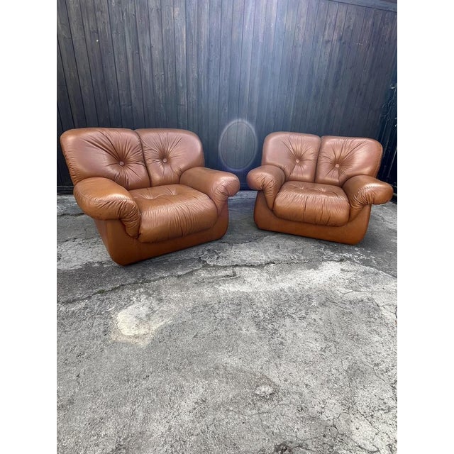 Set of 2 Mid-Century armchairs in cognac-colored leather. They date back to the 70s. Intact and in good condition, very...