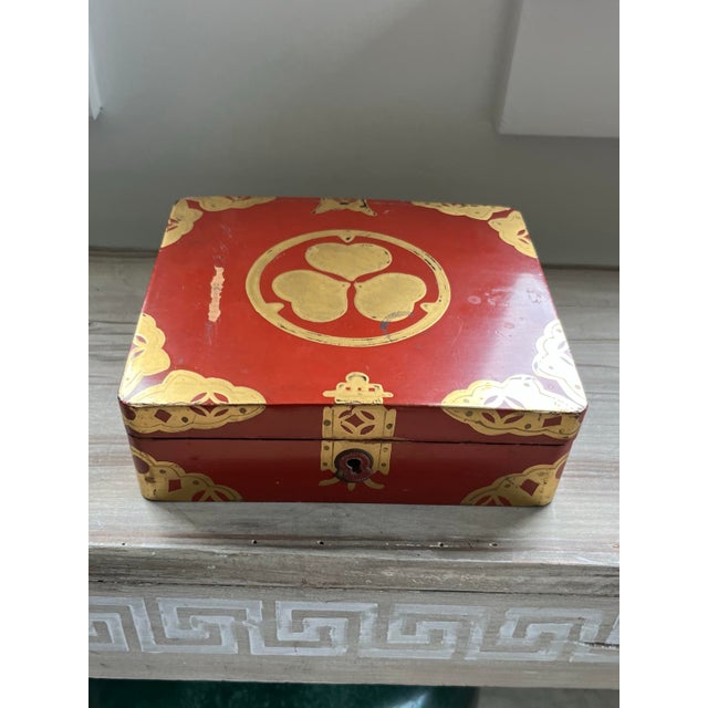 An antique asian red lacquered box accented in gold.