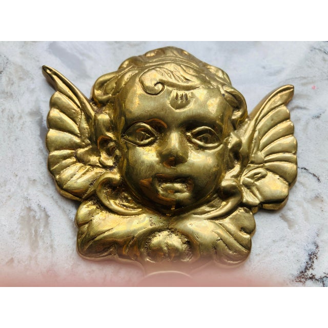 This solid brass robe hook has a putti as the design Width 4.5 Height 5.5 Depth 2
