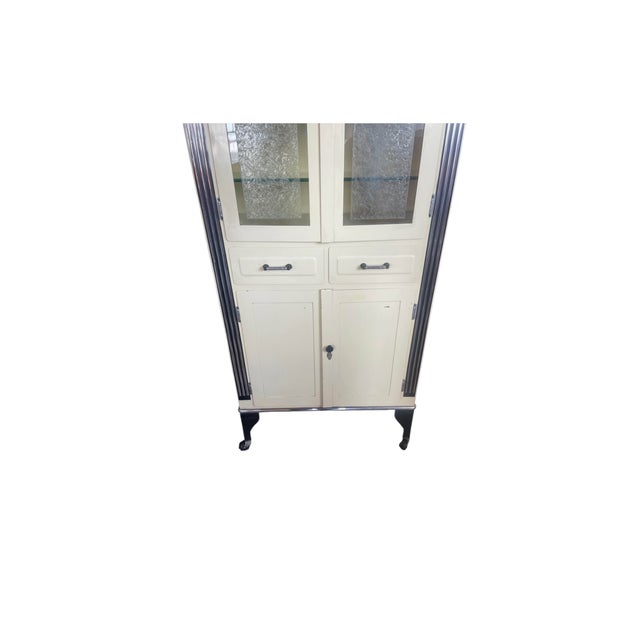 Awesome art deco doctors cabinet. Has age related ware. No key. Hard rubber wheels are deteriorating. The cabinet light...