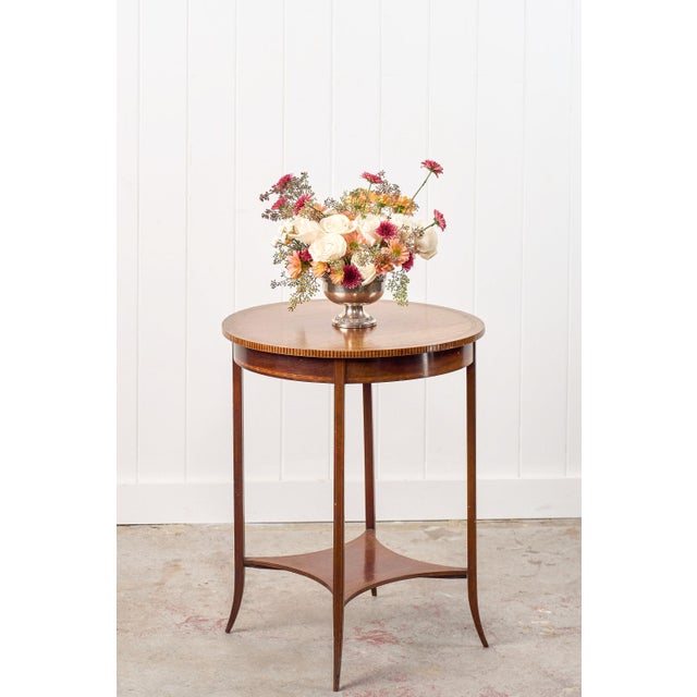 This Edwardian lamp table features a round wood top with an inlay border and a checkered outer edge detail. Sitting on...