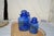 Set of three cobalt blue canister sets from the mid 20th century. Handblown with daisy lids. Two have small chips. This...