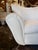 A pair of upholstered armchairs attributed to Guglielmo Ulrich. Their broad, sculptural backs rise above gently curved...