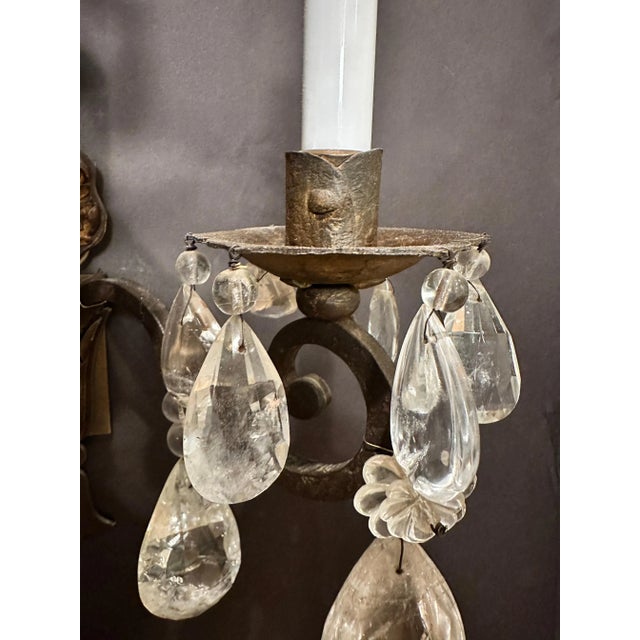 Pair of Gothic/Renaissance form wrought iron and gilt tole frame wall sconces dressed with rock crystal pendants. Rock...