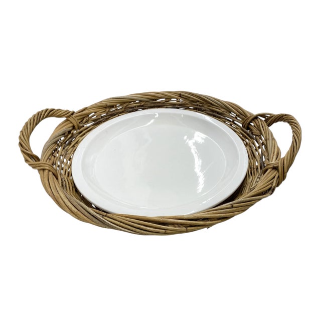 A round woven tray with two handles and a round white porcelain serving platter.