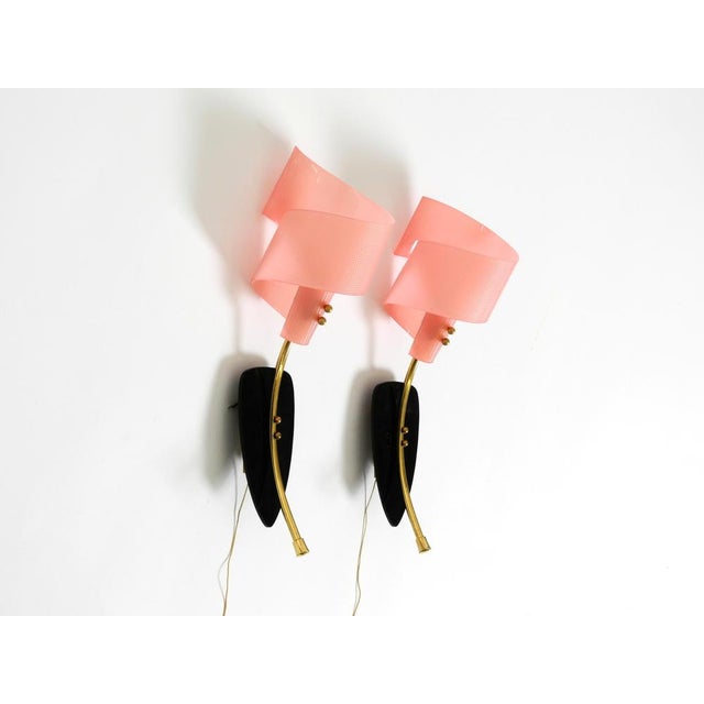 A pair of rare mid-century modern wall lamps featuring rolled pink acrylic glass shades. a beautiful design, typical of...