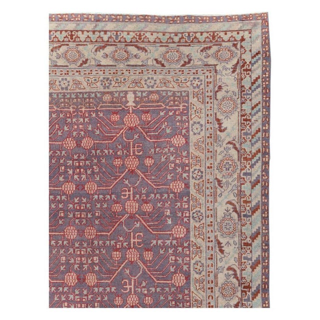 An antique East Turkestan Khotan room size carpet handmade during the early 20th century. Measures: 9' 6" x 14' 2".