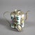 A Chinese miniature teapot offers porcelain vessel with hand painted figures, housed in silver overlay having figures,...