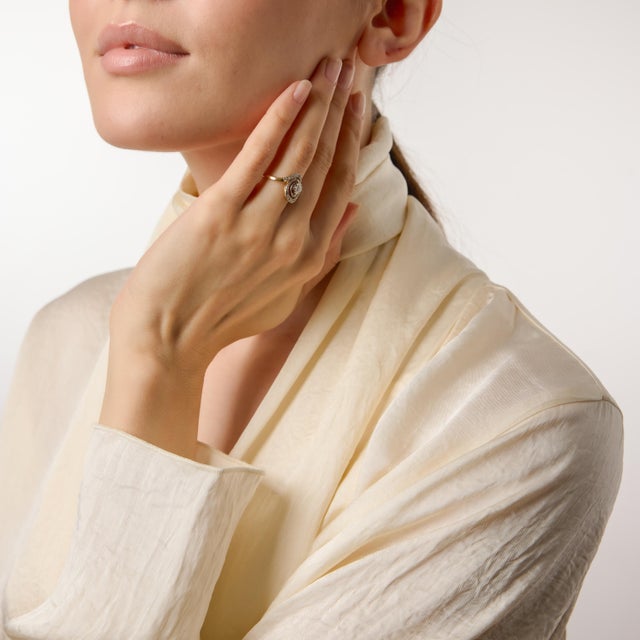 A graceful expression of early twentieth-century elegance, this Edwardian swirl ring captures the delicate artistry of the...