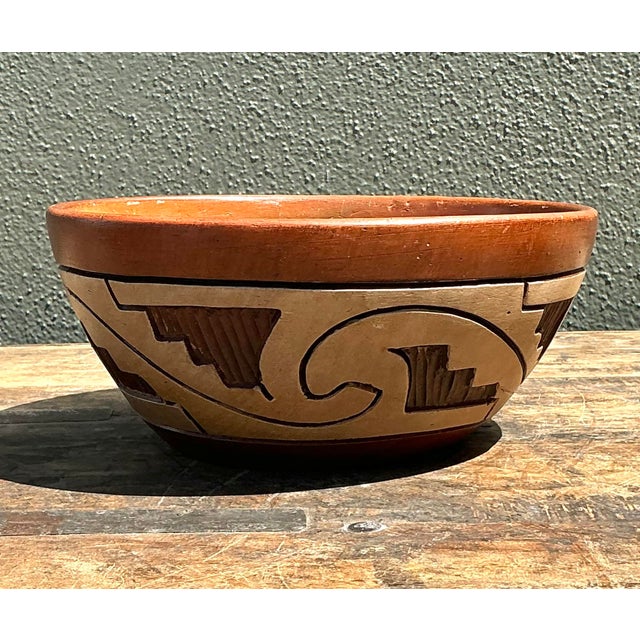 This vintage terracotta bowl is a striking example of artisan-crafted folk pottery, likely inspired by Southwestern or...