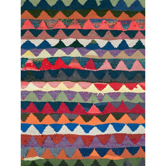 This Mid-20th century Persian flatweave kilim is composed of rhythmic horizontal bands filled with repeating triangular...
