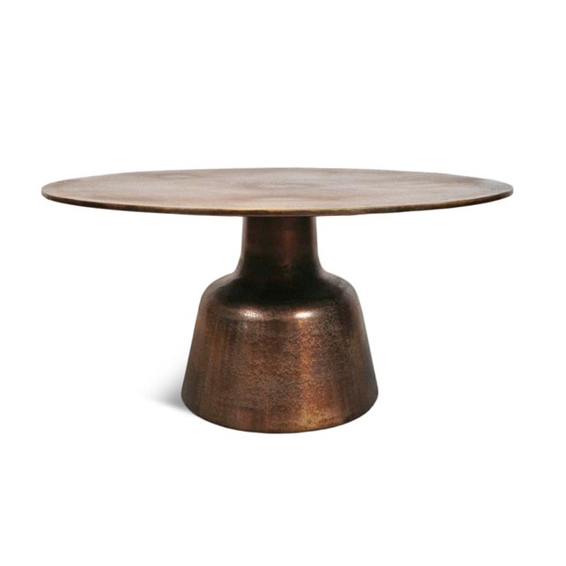 Modern round cast aluminum coffee table featuring a rich antiqued brass finish with beautifully aged character. Subtle...