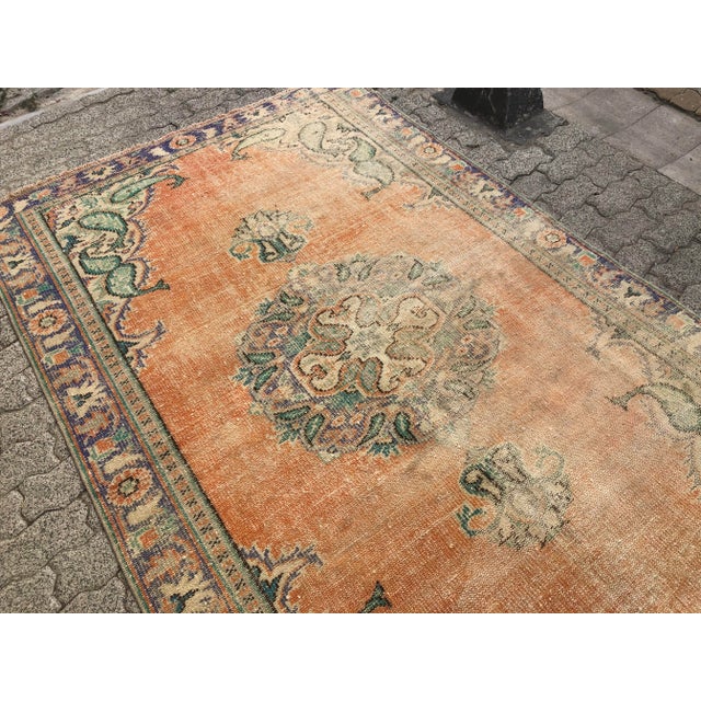 This is a vintage Turkish Oushak rug from the 1960s. The piece was hand-knotted.