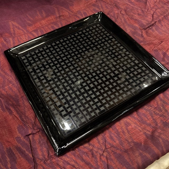 An elegant black lacquer small square tray with a tight pattern of woven black lines that create lovely small square...