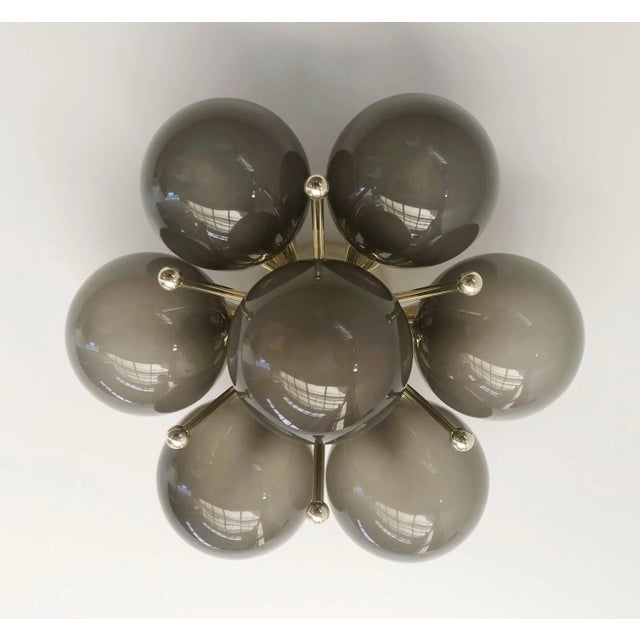 Italian flush mount with seven frosted smoky Murano glass globes mounted on solid brass frame in lacquered polished brass...
