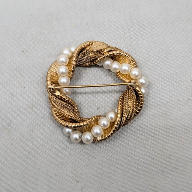 1960s goldtone textured faux-pearls wrapped circle brooch with security clasp. Marked "NAPIER©" on a cartouche on the...