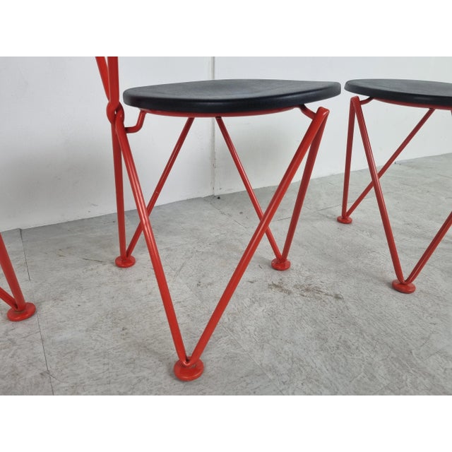 Red metal design dining chairs attributed to Jozef Hoffmann. Gorgeous 1980s metal wire tripod frames with a black...