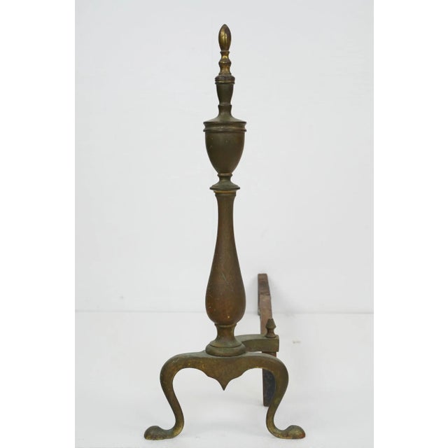Federal style fireplace brass andirons featuring a classic steeple design, a slender stem, and curved legs. The leg...