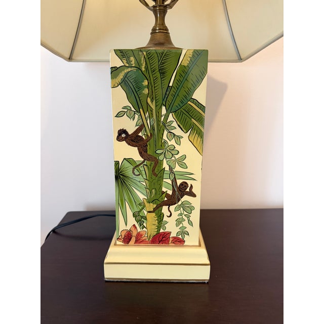 Playful Regency-style table lamp by Wildwood, featuring hand painted tropical leaves with monkeys climbing among them....