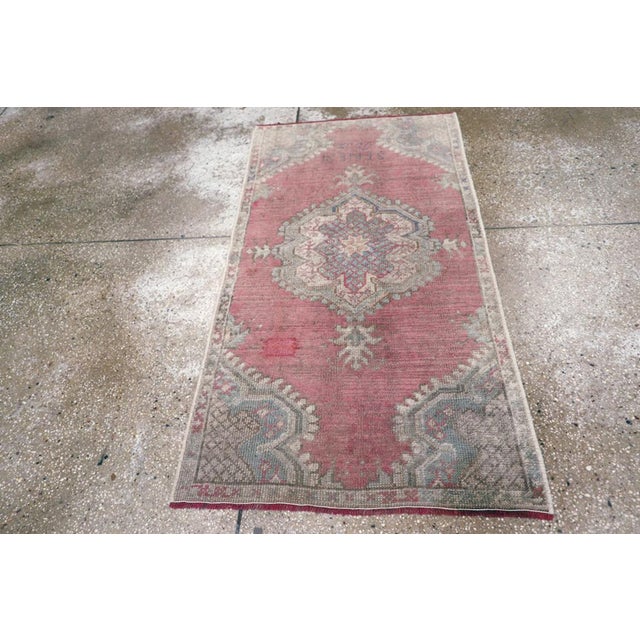 An antique Turkish Oushak throw rug. The medium brown open field is accented by a bud-edged pendanted ivory medallion and...
