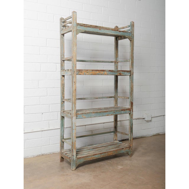 This vintage distressed blue wooden shelf features a beautifully weathered finish and a tall, open-frame construction,...