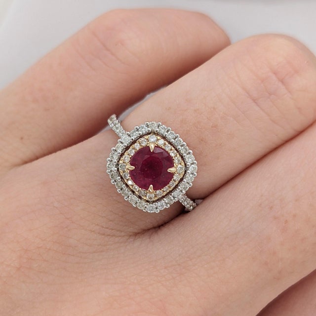 A ruby takes centre stage in a vivid red at the centre of this solid 14K yellow gold ring, surrounded by sixty earth-mined...