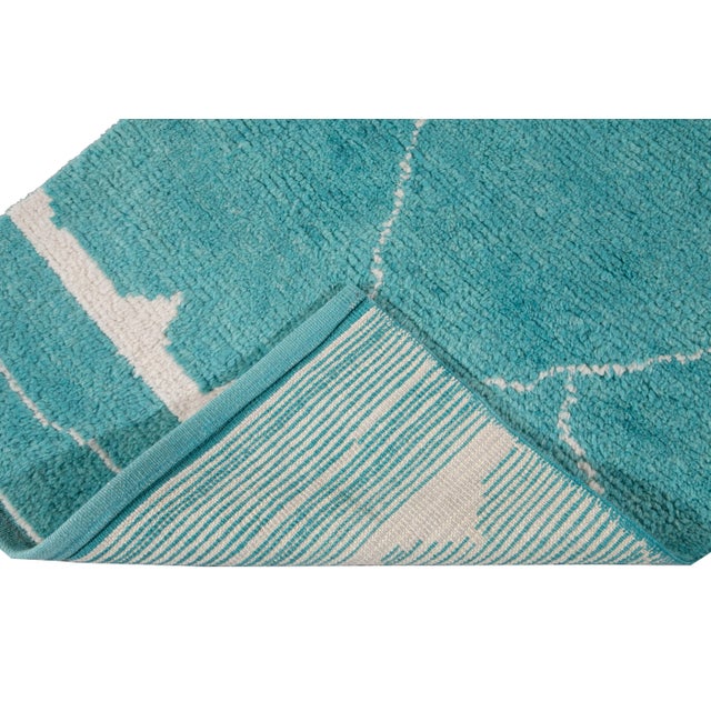 Beautiful contemporary Moroccan style runner hand-knotted wool rug with a turquoise field. This Modern rug has an ivory...