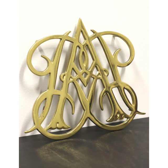 A pair of Queen Anne cypher trivets by Virginia Metalcrafters, made for Colonial Williamsburg. Solid brass depicting the...