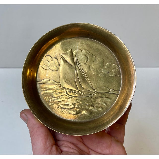 Polished bronze dish/plate with center-motif of a sailboat fighting the waves. Designed and manufactured by Ægte Ildfast...