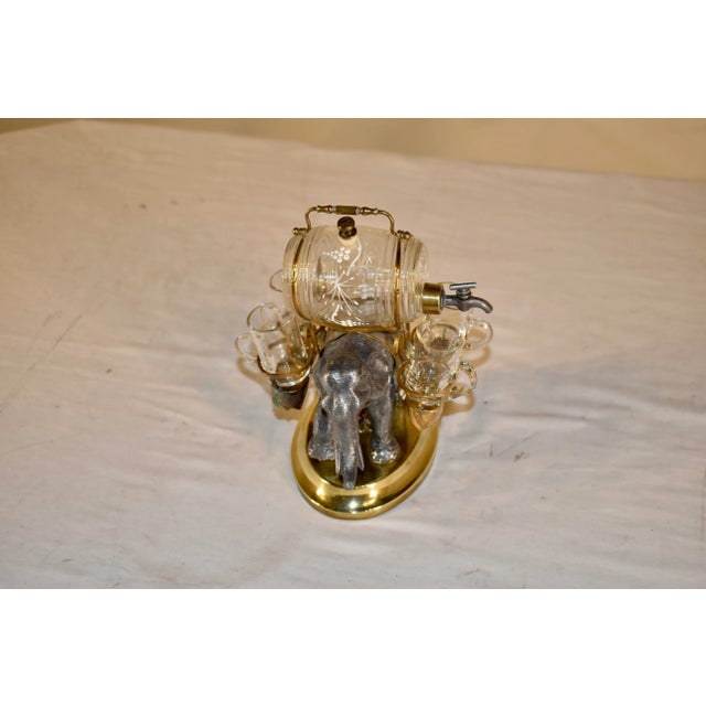 This is an extremely fine neoclassical French ornamental cast bronze, brass, and glass liqueur set, circa 1840. This...