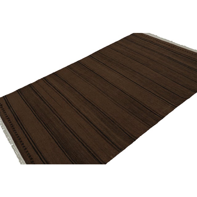 Handwoven in wool, circa 1950-1960, this 5x8 vintage Afghan tribal kilim rug with chocolate brown and black stripes is an...