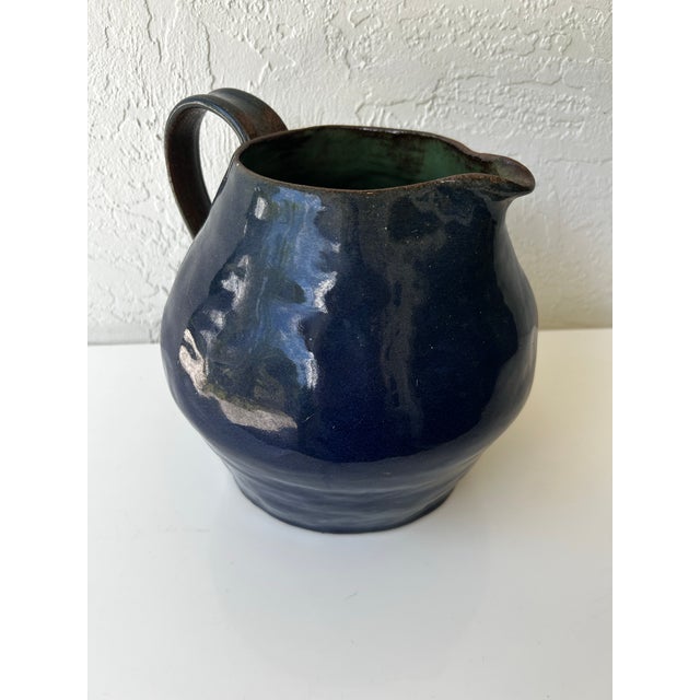 Handmade, studio pottery pitcher, glazed in and out. Cobalt blue exterior with a green, almost verdi gris interior. Signed...