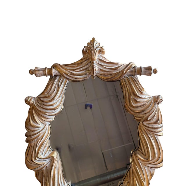 This decorative wall mirror from John Richard has the look of being framed in heavy drapery. Made of resin or some other...