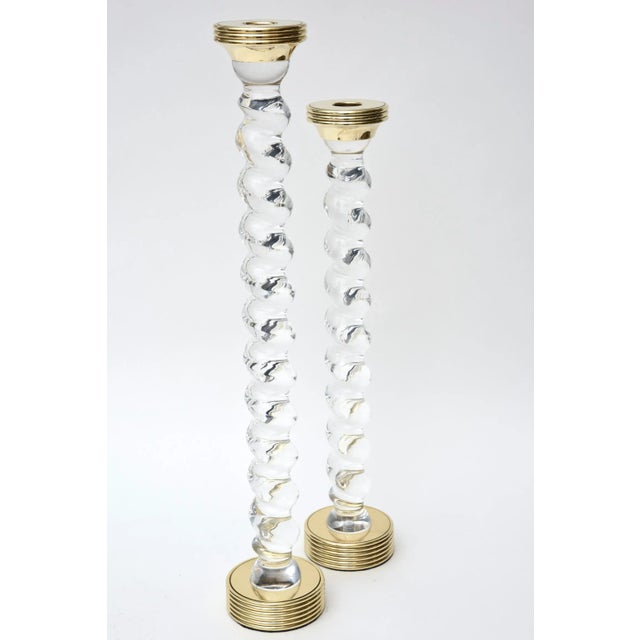 This wonderful pair of vintage heavy twisted tall lucite and sold brass candlesticks are alternating size and are rare....